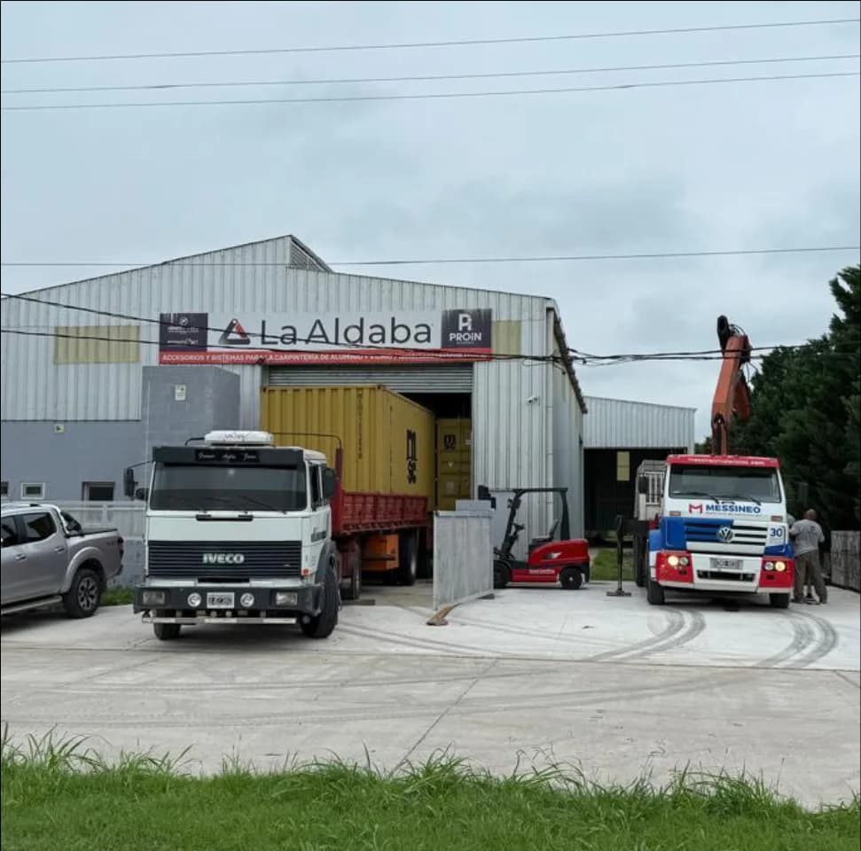 Frente del depósito de La Aldaba en Roldán con camiones de despacho